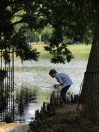 Young boy is playing on the river bank