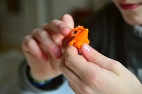 closeup photo of orange toy in hands child