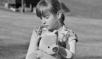 girl with teddy bear in black and white