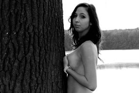 photo of a naked girl by a tree