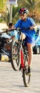 child boy in helmet doing bicycle trick