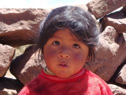 The face of the child on the background of stones, peru