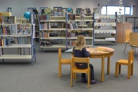 child girl reading books in library