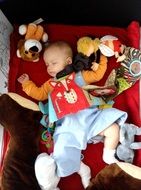 baby sleeps among soft toys