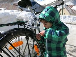 child repairs bicycle