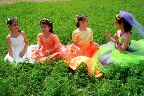 girls in colored dresses of princesses on a background of green nature
