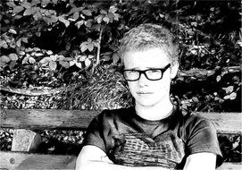 man in glasses on the park bench