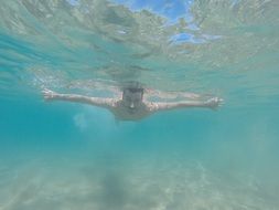 man swims in clear water