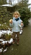 Child in a jacket with food in hands