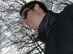 man in sunglasses on a background of an autumn tree