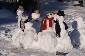 dressed snowman family outside in winter