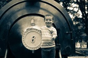 black and white photo of a child near a train