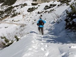 man is hiking on the snowy mountain in winter