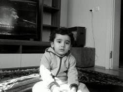 black and white photo of a child on a carpet