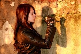 girl with a knife near an old stone wall