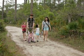 family is walking along a forest road