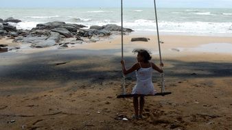 girl on a swing on the beach