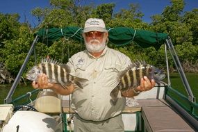 fisherman with two fish on the boat