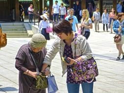 woman helping old lady at street, japan, tokyo