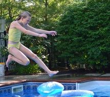 energetic girl jumping into the pool