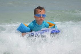 child in waves on a sunny day