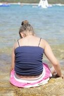 child girl sits on beach