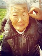 portrait of old asian woman in winter clothes
