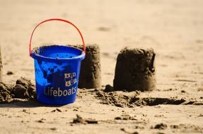 sand cakes and blue bucket on the beach