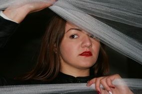 brown-eyed girl looking from behind the veil