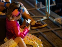 child in headphones looking at the phone