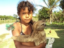 girl is holding a sloth