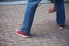 man drawing with chalk on the sidewalk