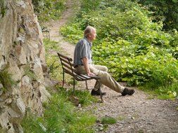 man rests on the bench among the plants