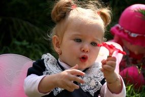 baby girl with a pink flower in hand