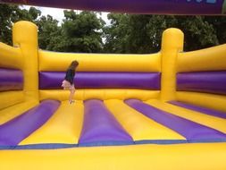 girl on an inflatable yellow trampoline