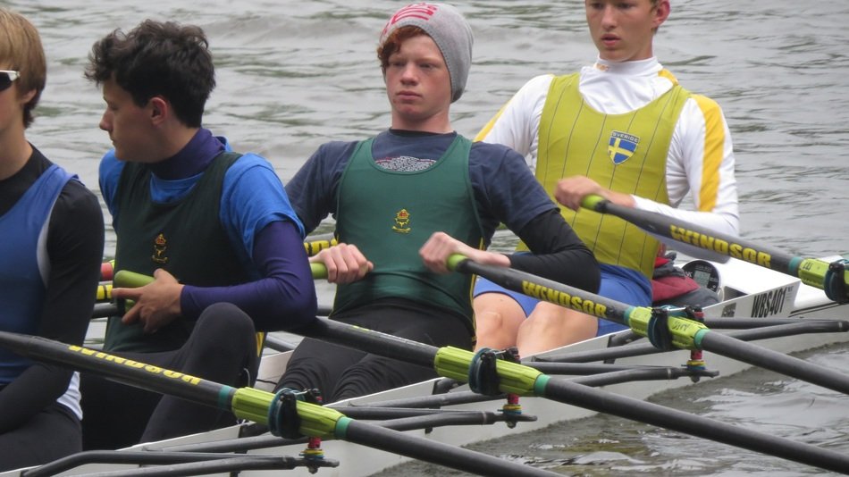 boys row in a boat on the water
