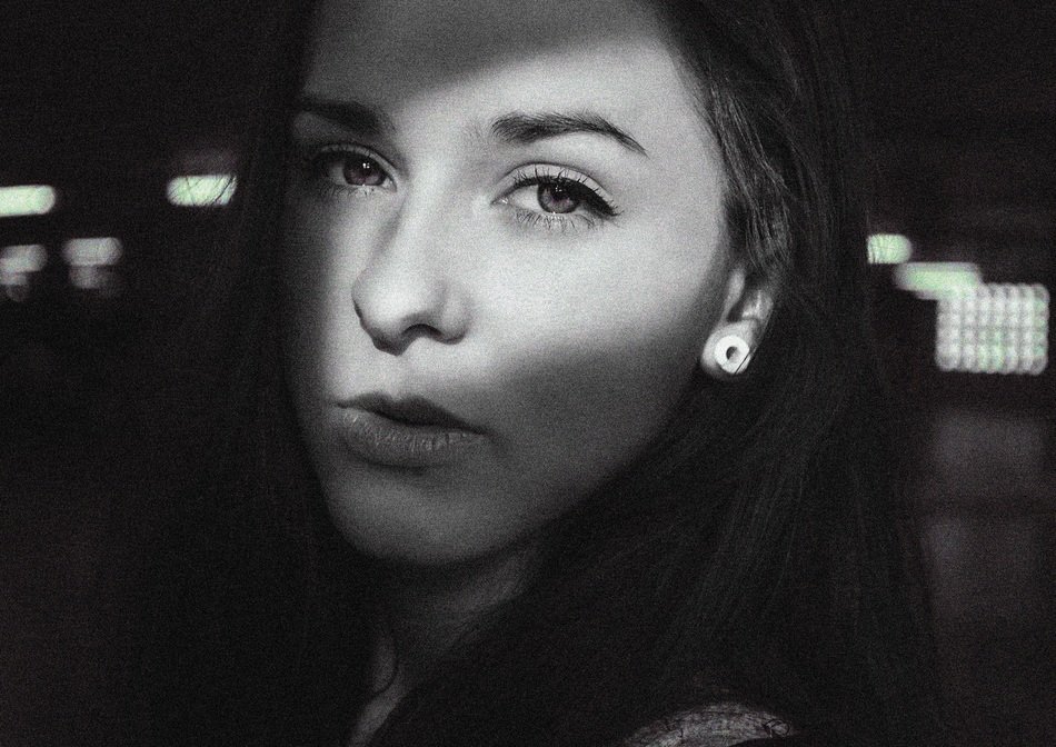 Black and white photo of a girl in the dark in the sunlight