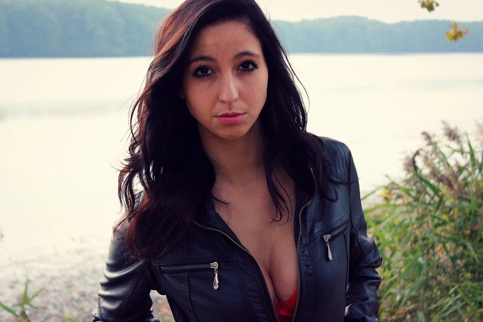 beautiful girl with a deep neckline on the background of the lake