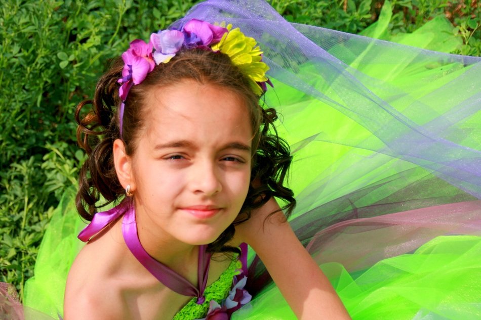 girlie in the colored dress on the background of summer nature