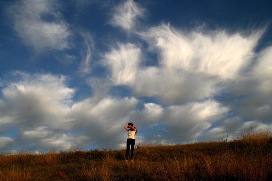girl on a background of autumn nature and beautiful clouds
