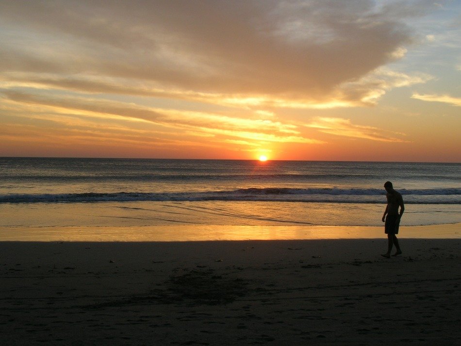 man on the beach during sunset
