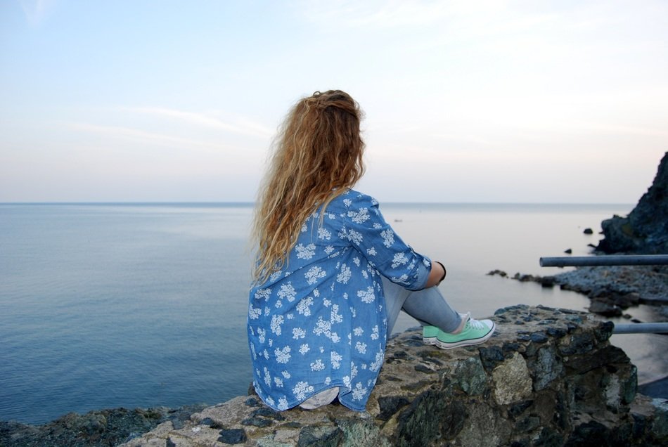 girl with long hair looks into the sea