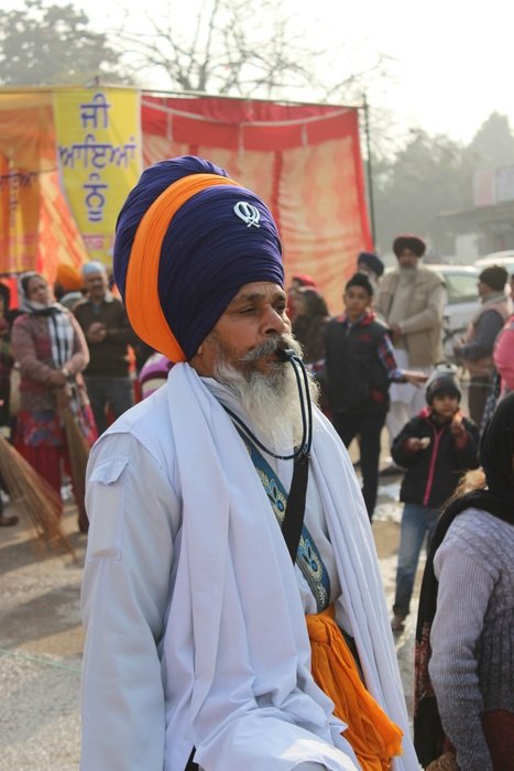 old sikh man with whistle among people