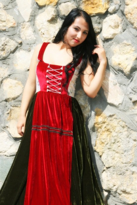 Princess girl in a dress on a background of a stone wall