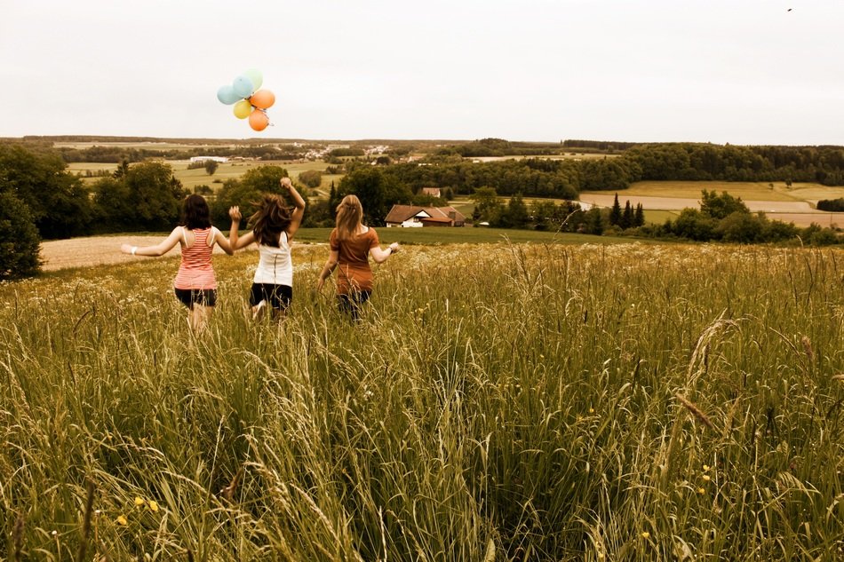 girls with balloons among the meadow