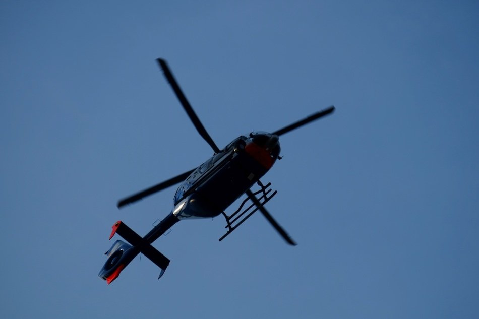 black helicopter high in the sky