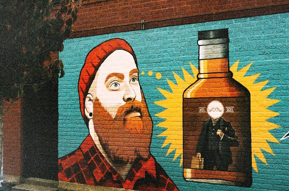drawing of a man with a beard and a bottle on the wall