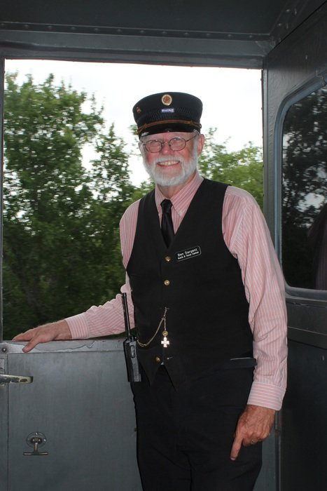 conductor in traditional costume on the railroad