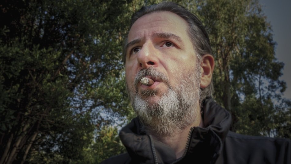 selfie of a bearded man with a cigar