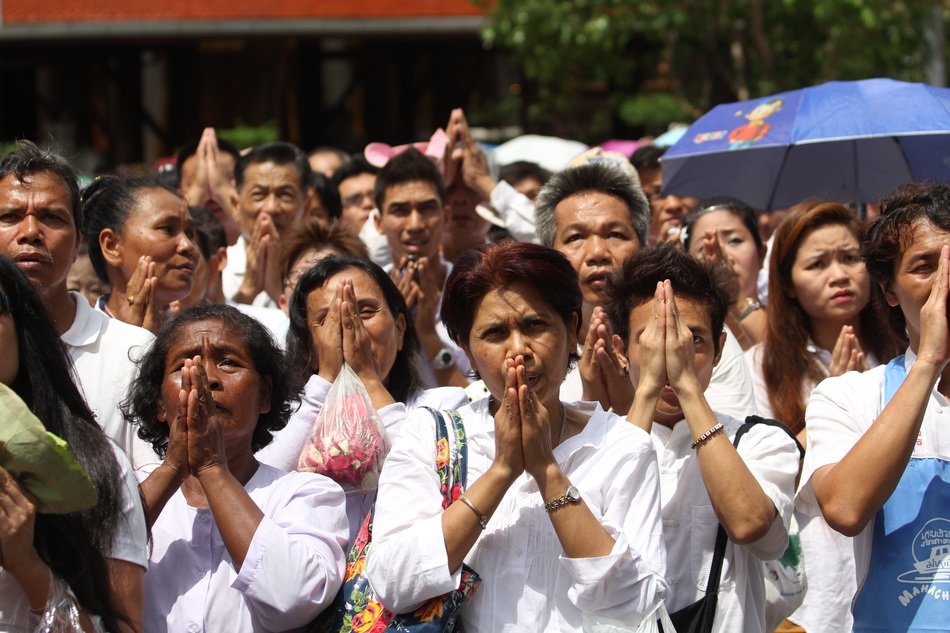 People pray on the street near a Buddhist temple.